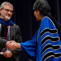 Male faculty shaking President's hand